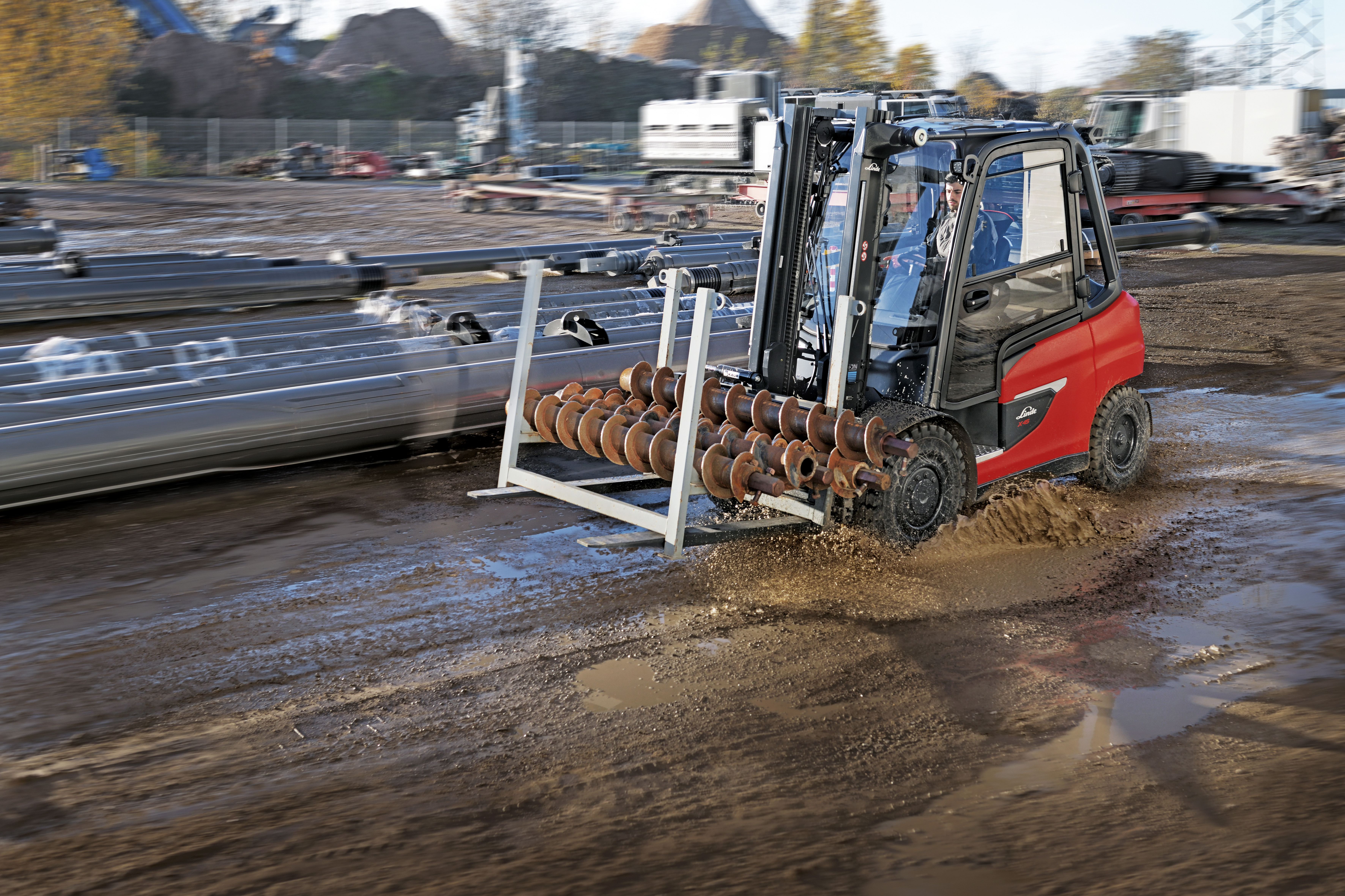 Linde E50 heftruck rijdt door modder