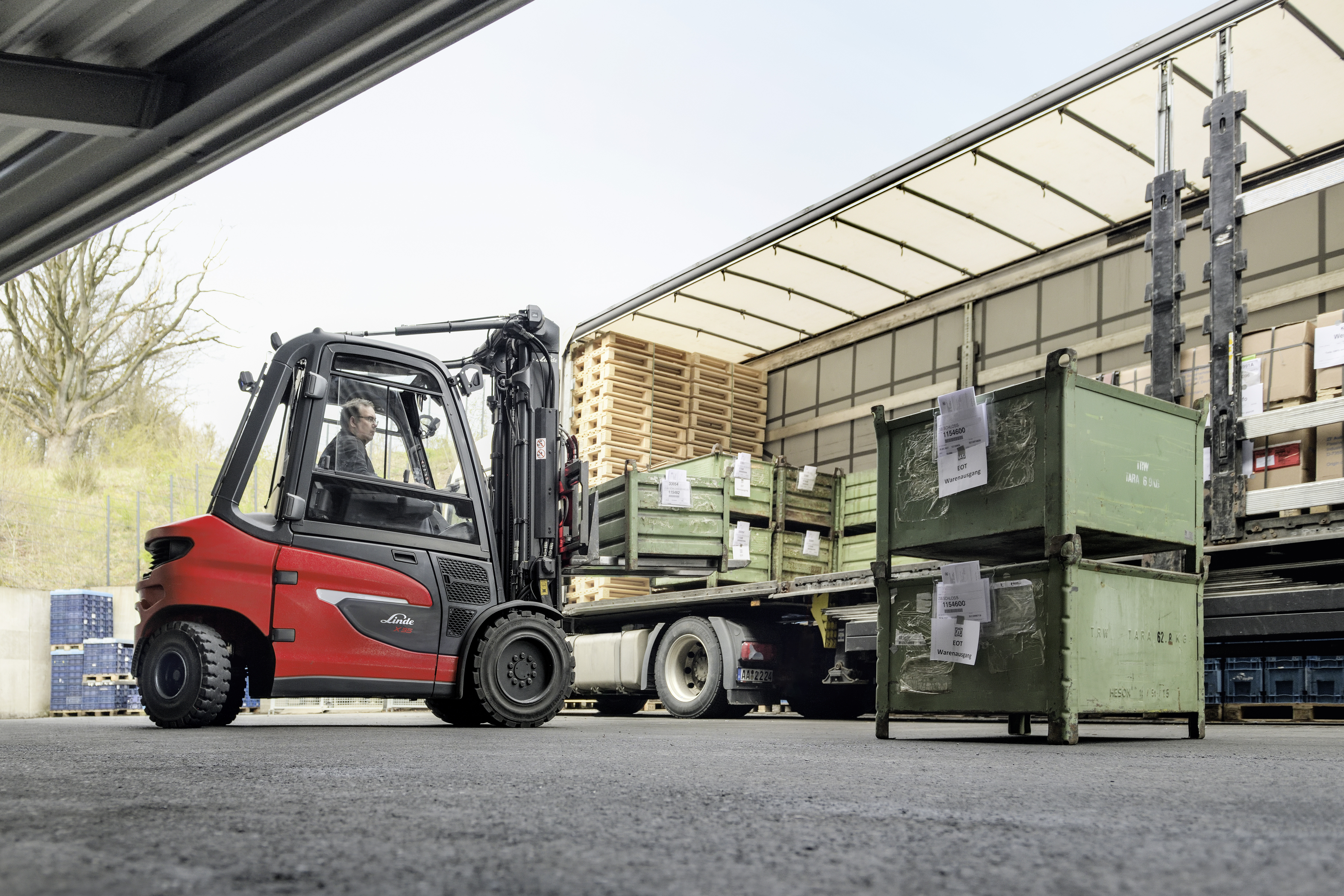 X35 elektrische heftruck laadt zware bakken in_uit vrachtwagen onder afdak