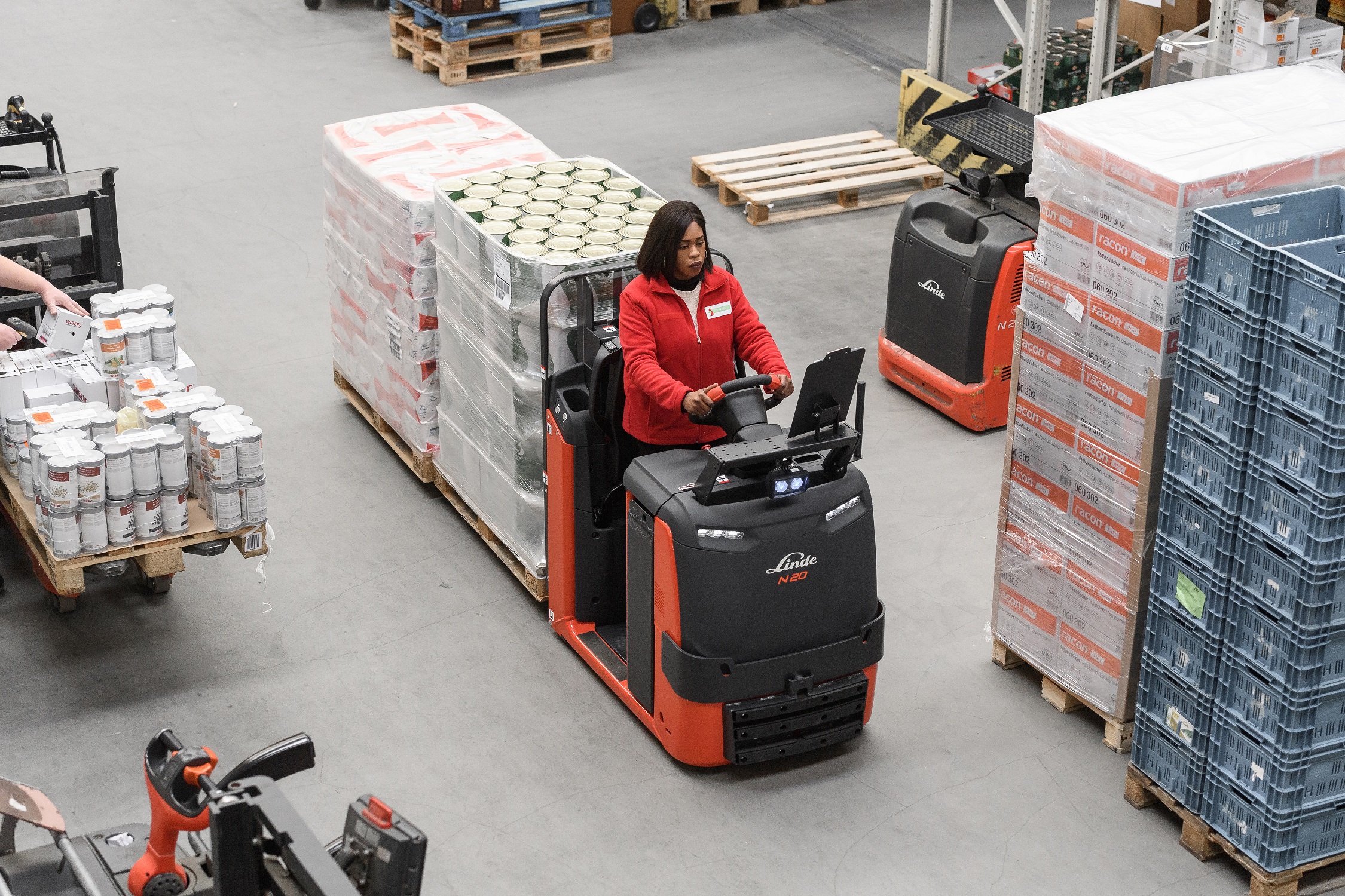 Linde N20 C LX orderverzameltruck met vrouwelijke operator die goederen op pallet laadt